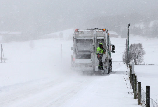 Renovasjonsbil på veien, i snø og kulde