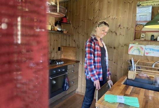 Astrid Fiskvik ved kjøkkenbenken der de sorterer restavfall og matavfall på hytta.